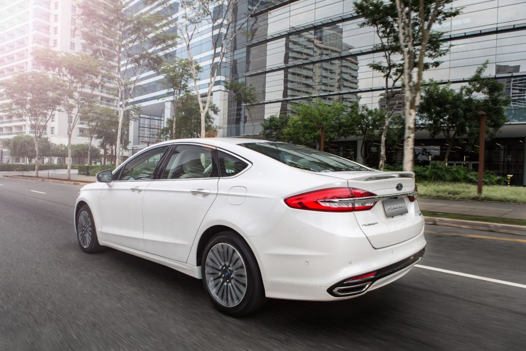 FordFusion2017 2 e1482500350398 A Ford trocou a alavanca de câmbio do Fusion 2017 por um novo seletor rotativo eletrônico, chamado E-Shifter, que além de criar um espaço mais funcional no console conta com uma função adicional de segurança. Quando o motorista vai sair do carro – situação que o sistema identifica usando vários sensores – ele coloca o câmbio automaticamente no modo de estacionamento para evitar acidentes.