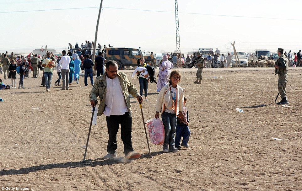 Fugindo: sírios carregam seus pertences perto da fronteira com a Síria 
