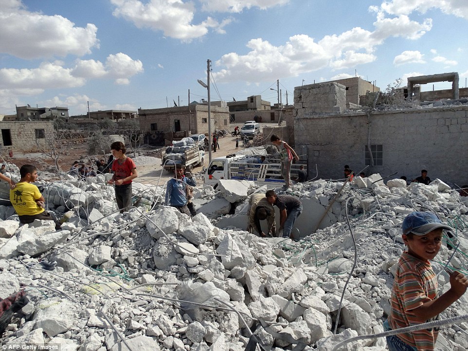 Os restos de uma casa em uma vila perto de Aleppo são inspecionados após ser destruída